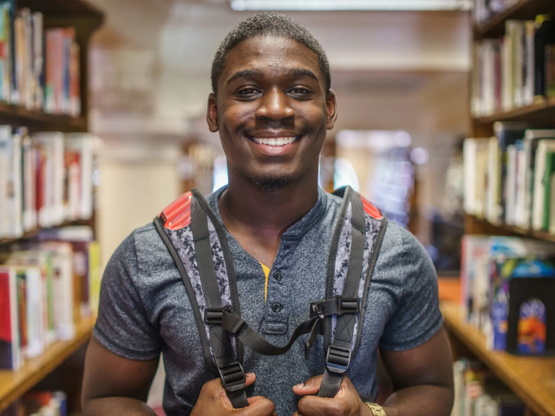 black student with backpack in a library